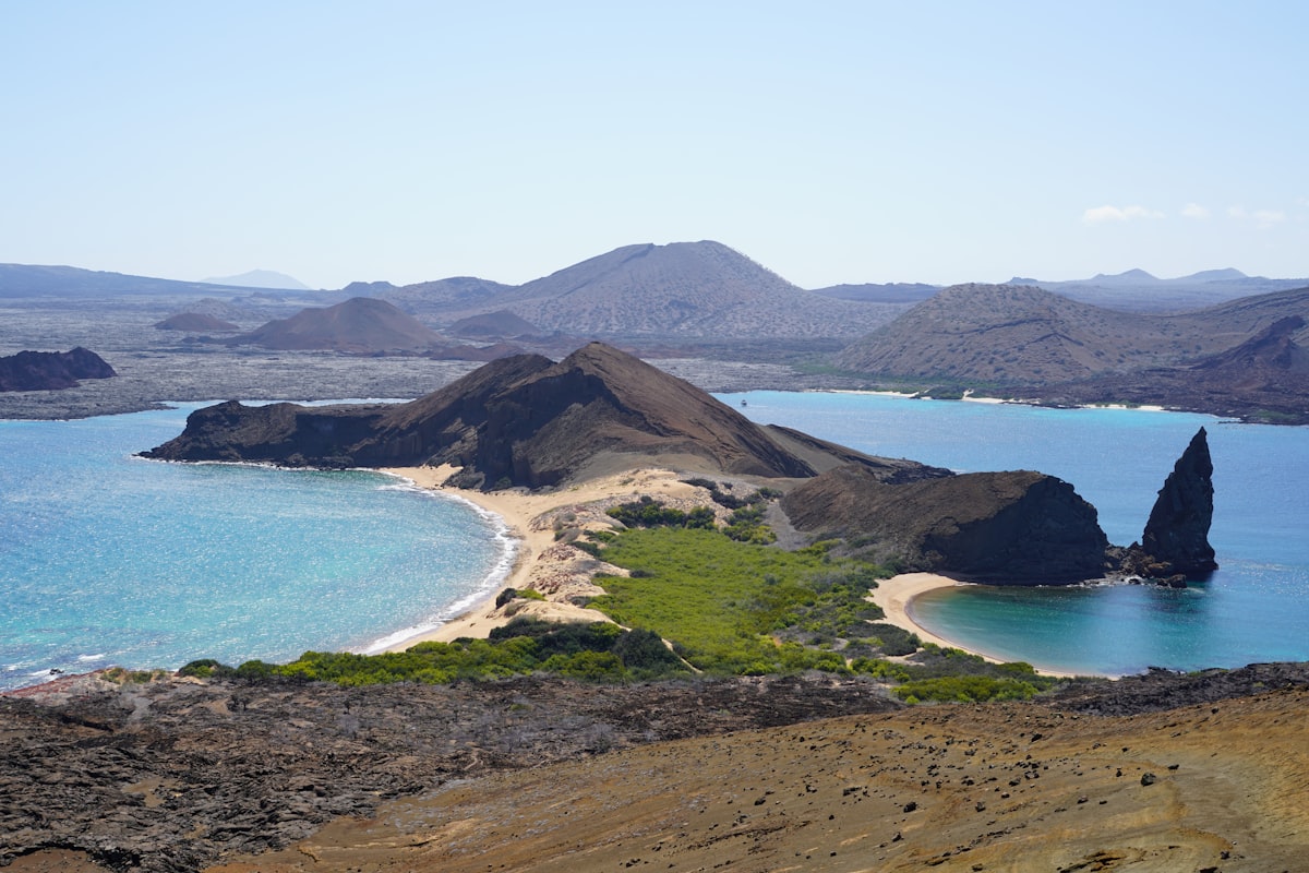 An island with a sandy beach and blue water in the Galapagos archipelago