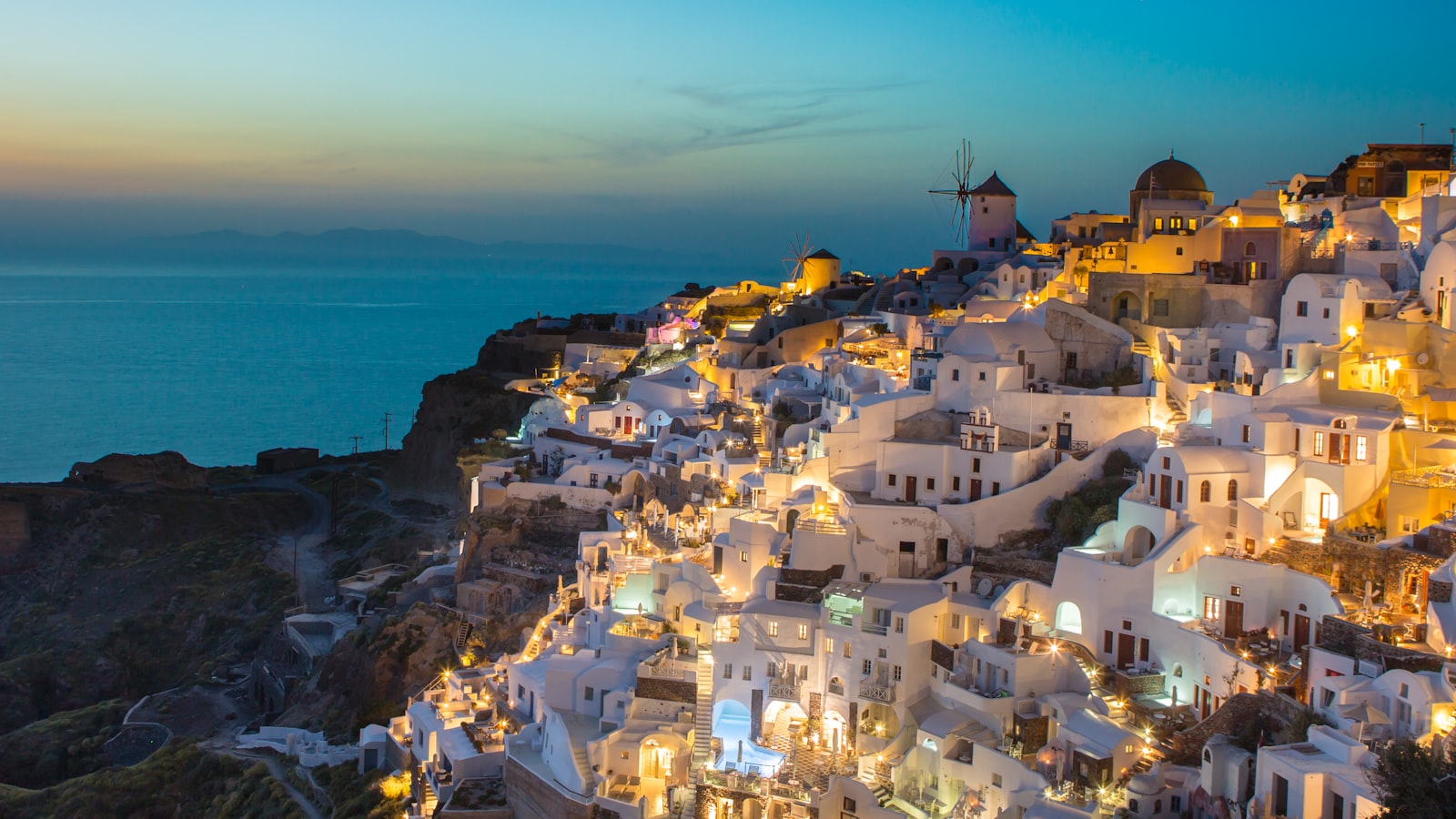 White and brown houses on the cliffs above the sea in Santorini, Greece